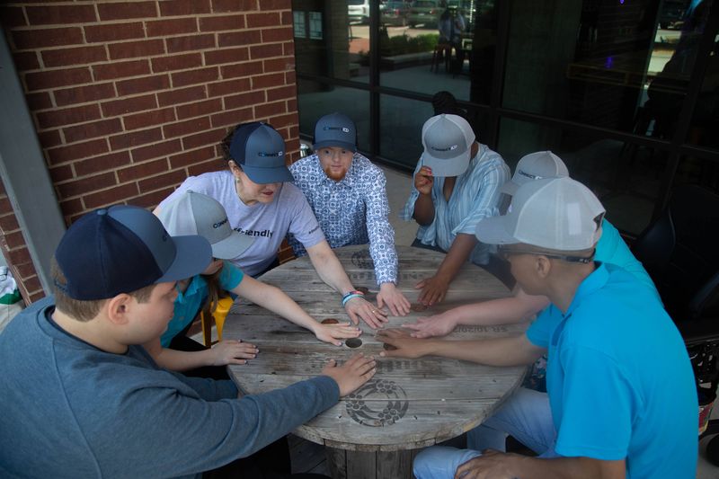 A team puts their hands together over a table.